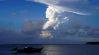 Foto diambil pada 21 Desember 2021 menunjukkan awan gas putih naik dari letusan Hunga Ha'apai terlihat dari garis pantai Patangata dekat ibu kota Tonga, Nuku'alofa. (MARY LYN FONUA / AFP)