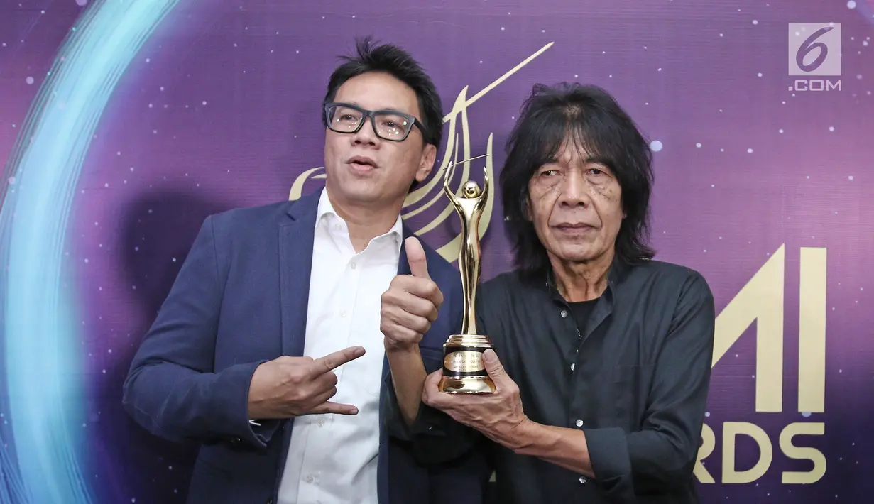Personel God Bless, Ian Antono memenggang piala usai meraih penghargaan Anugerah Musik Indonesia (AMI) Awards 2017 di Teater Garuda TMII, Jakarta, Kamis (16/11). (Liputan6.com/Herman Zakharia)
