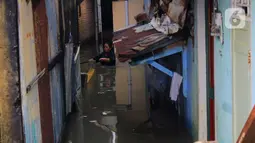 Aktivitas warga di tengah banjir yang merendam kawasan Kampung Melayu Kecil, Bukit Duri, Jakarta, Selasa (25/2/2020). Banjir tersebut akibat luapan sungai Ciliwung. (merdeka.com/magang/ Muhammad Fayyadh)