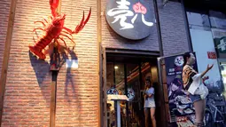 Pemilik restoran Ke'er, Lu Lu (27) berbincang dengan pengunjung di depan rumah makan miliknya yang telah dibangun sejak satun lalu tersebut di Beijing, China, (26/5). (REUTERS/Kim Kyung-Hoon)