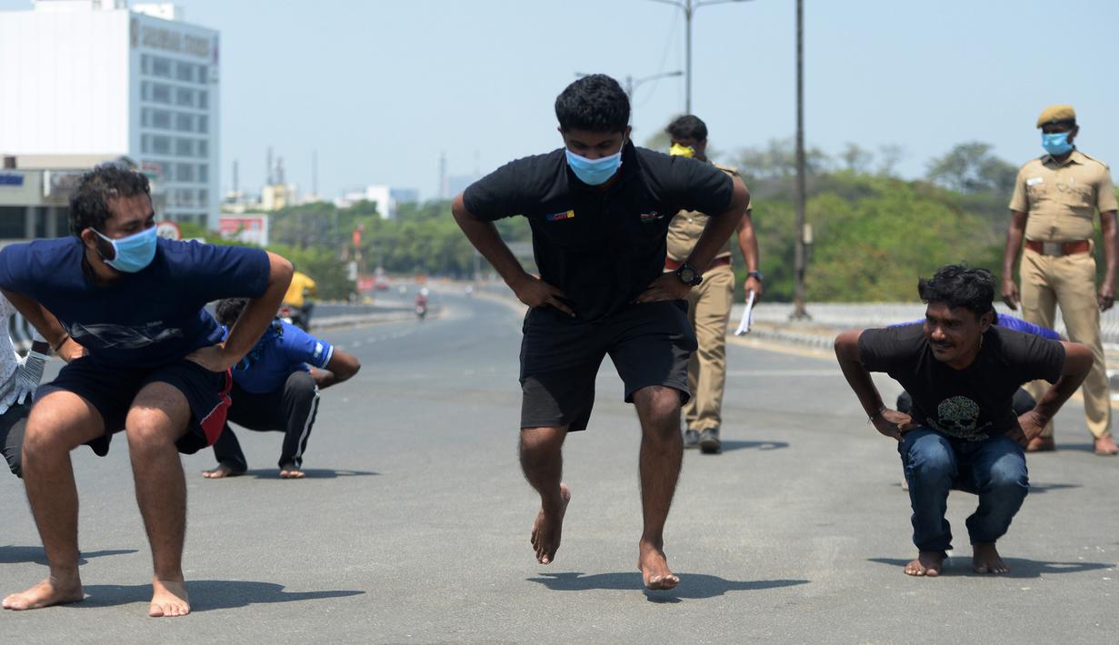 Orang-orang melakukan sit-up tanpa alas kaki sebagai hukuman karena keluar rumah selama pemberlakukan penguncian wilayah (lockdown) di Chennai, Rabu (1/4/2020). Pemerintah India menerapkan kebijakan karantina wilayah atau lockdown dalam memerangi Virus Corona COVID-19. (Arun SANKAR / AFP)