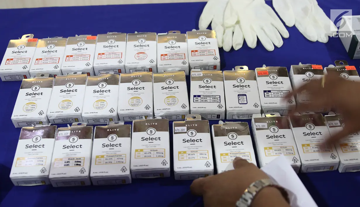 Petugas merapikan barang bukti saat rilis liquid vape mengandung ganja di Mapolres Jakarta Selatan, Rabu (21/11). Polisi mengamankan dua tersangka dalam kasus penyalahgunaan liquid vape mengandung ganja ini. (Liputan6.com/Herman Zakharia)