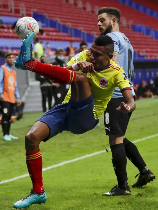 Bek timnas Kolombia William Tesillo mencoba mengontrol bola saat dibayangi gelandang Uruguay Nahitan Nandez dalam laga perempat final Copa America 2021 di Stadion Nacional de Brasilia, Brasil, Minggu (4/7/2021) pagi WIB. Kolombia mengalahkan Uruguay lewat adu penalti 4-2. (AP Photo/Silvia Izquierdo