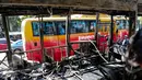 Penumpang bus melihat dari balik jendela sisa Bus Transjakarta yang terbakar di Halte UI Salemba, Jakarta, Jumat (3/7). Bus Koridor V jurusan Ancol-Kampung Melayu tersebut terbakar sekitar pukul 08.30 WIB. (Liputan6.com/Faizal Fanani)