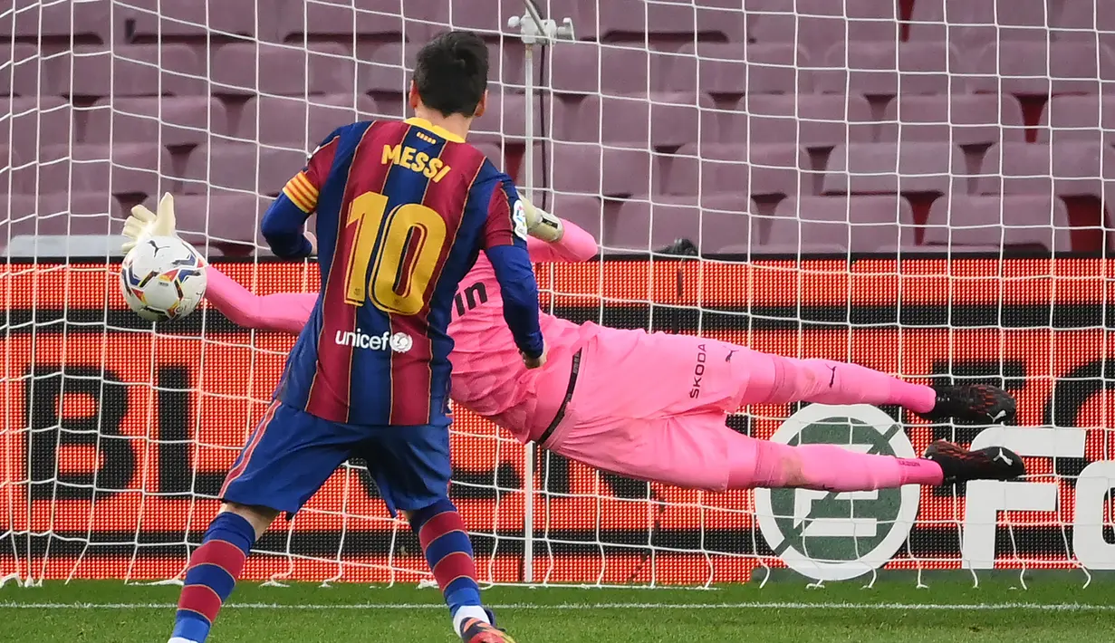 Kiper Valencia, Jaume Domenech, berhasil menepis eksekusi penalti striker Barcelona, Lione Messi, dalam laga lanjutan Liga Spanyol 2020/21 di Camp Nou Stadium, Barcelona, Sabtu (19/12/2020). Valencia bermain imbang 2-2 dengan Barcelona. (AFP/Lluis Gene)