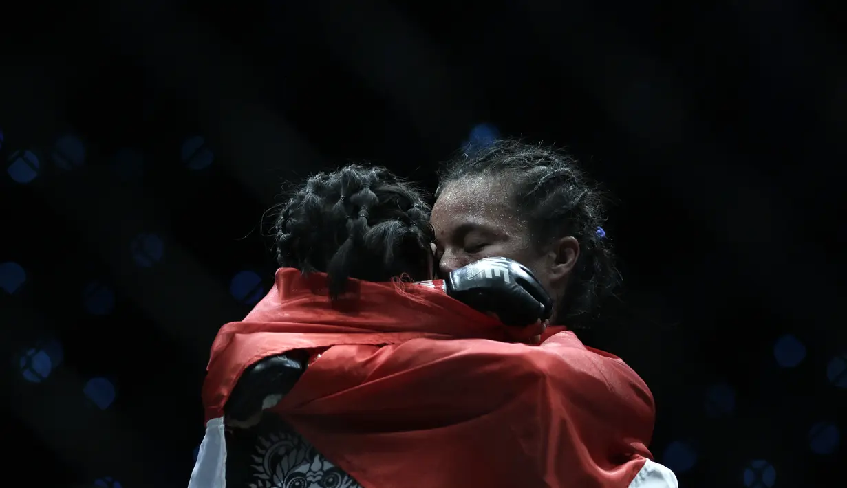 Petarung MMA asal Indonesia, Priscilla Lumban Gaol, memeluk Bozhena Antoniyar usai bertarung pada laga ONE Championships: Dawn of Valor di Istora Senayan, Jakarta, Jumat (25/10). Priscilla menang atas Bozhena. (Bola.com/Yoppy Renato)