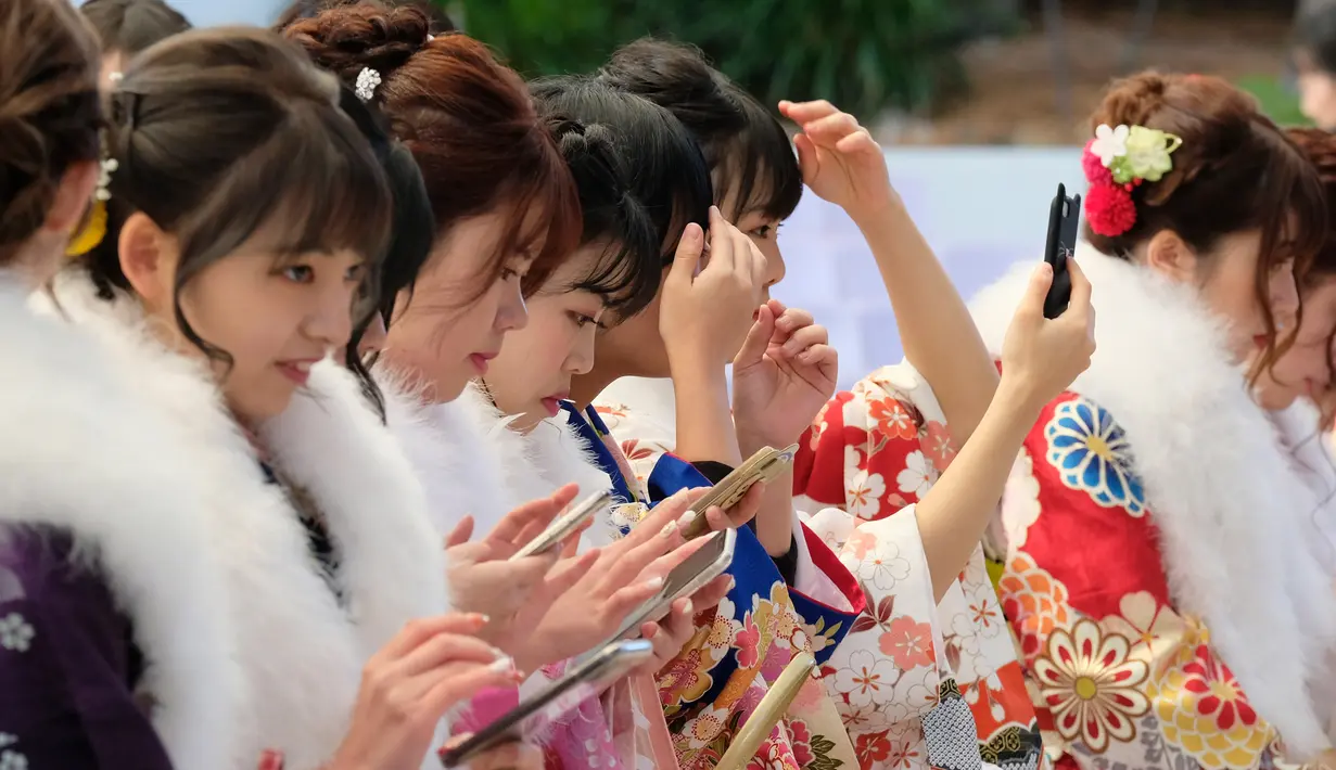 Sejumlah gadis Jepang mengenakan kimono berkumpul untuk upacara Coming of Age Day atau Hari Kedewasaan di Tokyo Disneyland, di Urayasu, Senin (13/1/2020). Coming of Age Day atau Hari Kedewasaan ini menandakan diperbolehkannya merokok, mengonsumsi alkohol dan mengikuti Pemilu. (Kazuhiro NOGI/AFP)