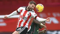 Pemain Tottenham Hotspur, Steven Bergwijn, duel udara dengan pemain Sheffield United, Oliver Norwood, pada laga Liga Inggris di Stadion Bramall Lane, Minggu (17/1/2021). Tottenham Hotspur menang dengan skor 3-1. (Mike Egerton/Pool via AP)