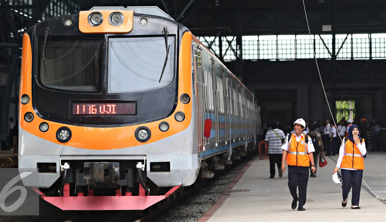 Petugas PT KAI berjalan disamping KRL saat dilakukan uji coba jalur di Stasiun Tanjung Priok, Jakarta, Senin (23/11). Stasiun seluas 3.768 meter persegi tersebut rencananya akan digunakan setelah renovasi Januari 2016. (Liputan6.com/Immanuel Antonius)