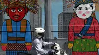 Pengendara sepeda motor melintas di depan mural Kota Jakarta, Tanah Kusir, Kebayoran Lama, Jakarta, Jumat (26/11/2021). Mural tersebut bertemakan Kota Jakarta dengan gambar ikon seperti ondel-ondel, Monas hingga transportasi. (Liputan6.com/Herman Zakharia)