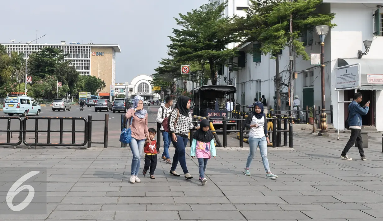Pejalan kaki melintas di area trotoar Kota Tua, Jakarta, Kamis (4/8). Pemerintah Provinsi DKI Jakarta membuat konsep lingkungan yang ramah bagi pejalan kaki di kawasan Kota Tua sampai Pasar Ikan. (Liputan6.com/Yoppy Renato)