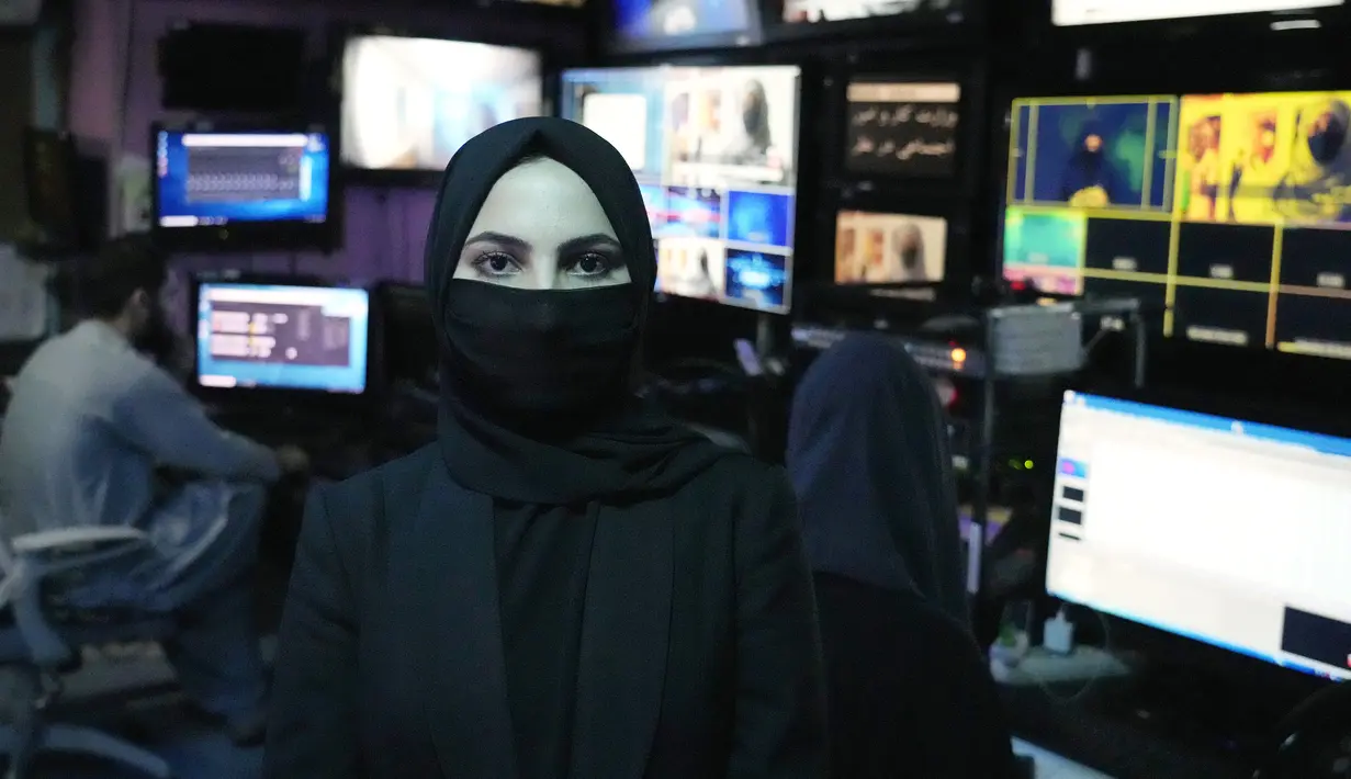 <p>Sonia Niazi seorang presenter atau pembawa acara TV bekerja di studio TOLO NEWS sambil menutupi wajahnya, di Kabul, Afghanistan, Minggu, 22 Mei 2022. Sejak Taliban kembali berkuasa pada Agustus 2021, mereka telah mengeluarkan berbagai dekret yang membatasi kebebasan perempuan. (AP Photo/Ebrahim Noroozi)</p>