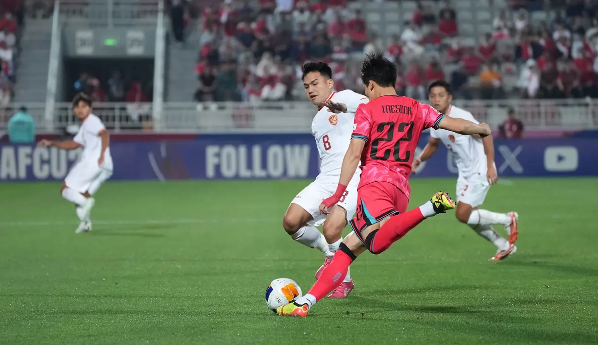Pemain Korea U-23, Lee Tae-seok menendang bola yang berusaha diblok pemain Timnas Indonesia U-23, Witan Sulaeman pada laga perempatfinal Piala Asia U-23 2024 di Abdullah bin Khalifa Stadium, Doha, Qatar, Jumat (26/4/2024) dini hari WIB. (Dok. PSSI)