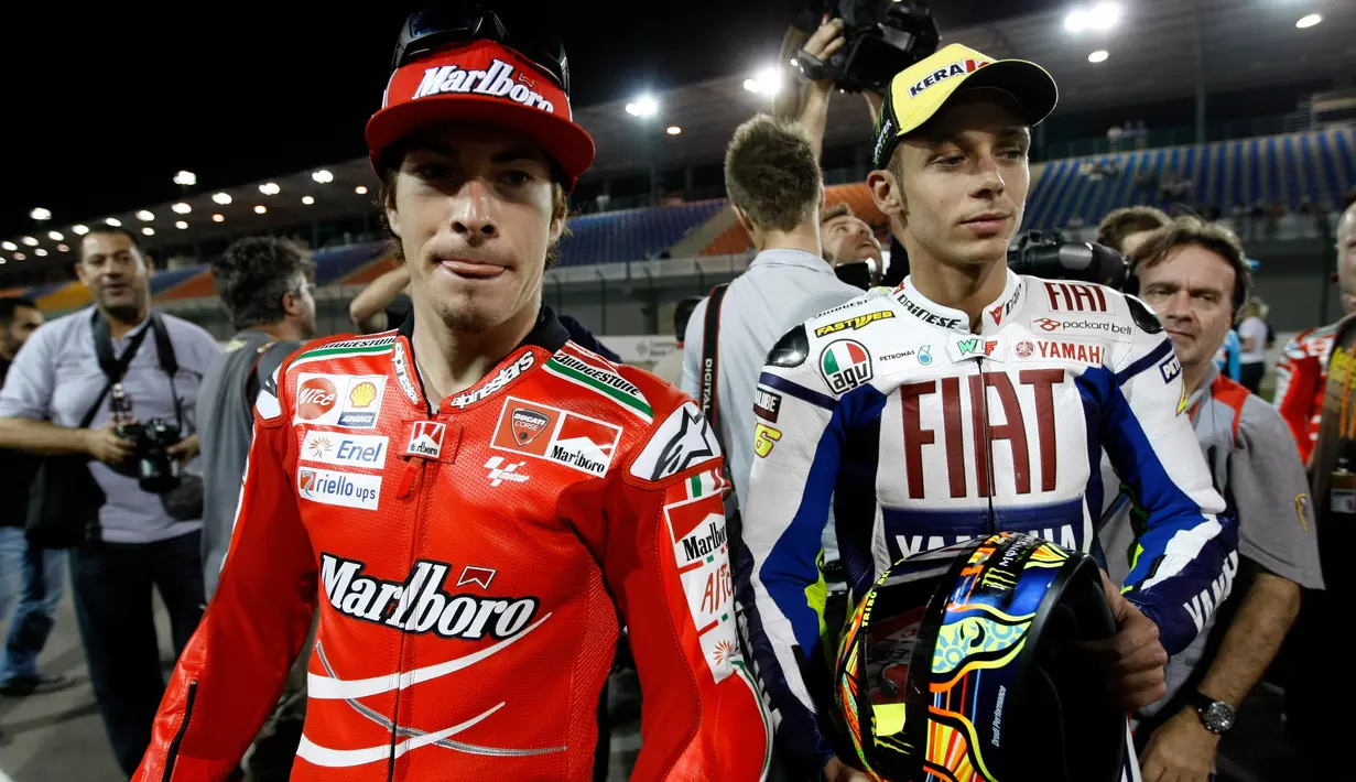 Nicky Hayden (kiri) dan Valentino Rossi saat menghadiri foto grup di Sirkuit Internasional Losail di Qatar, Jumat (10/4/2009). (AP Photo / Hassan Ammar)