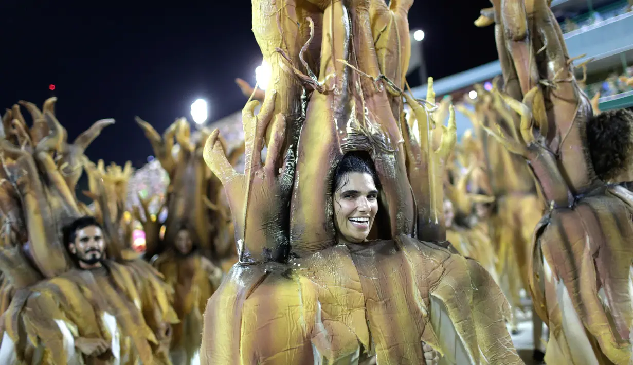 Penampilan sekolah samba Sao Clemente dengan kostum pohon saat perayaan karnaval di Sambadrome, Rio de Janeiro, Brasil, Minggu (11/2). Belasan sekolah samba papan atas mengikuti ajang ini. (AP Photo/Silvia Izquierdo)