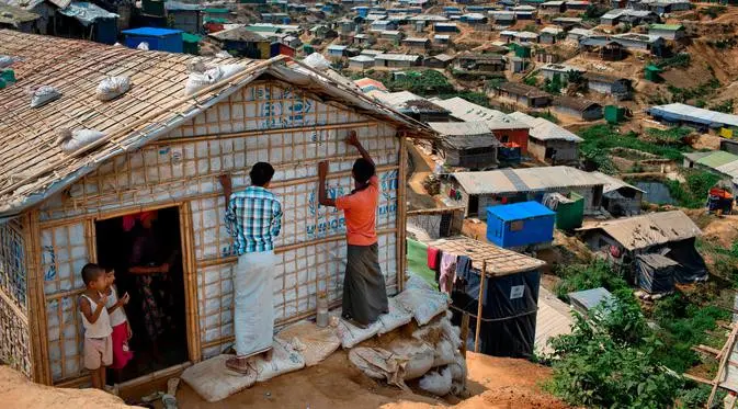 Pengungsi Rohingya memperbaiki rumahnya di Kamp Pengungsi Kutupalong, Bangladesh, 28 April 2018. Apabila hujan tiba, ada ancaman serius kamp pengungsi yang dibangun secara tidak teratur itu mengalami kebanjiran dan longsoran lumpur. (AP Photo / A.M. Ahad)