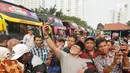 Ketua Umum PKB Muhaimin Iskandar berswafoto dengan peserta  mudik gratis PKB di Taman Ismail Marzuki, Cikini, Jakarta, Minggu (10/6). Mudik gratis PKB  tersebut bertajuk "C1NTA", singkatan dari Cak Imin untuk Indonesia. (Liputan6.com/Herman Zakharia)