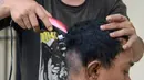 Seorang anak Punk dicukur rambutnya di Banda Aceh (9/1). Provinsi Aceh menjadi salah satu daerah di Indonesia yang menerapkan hukum Syariah bagi masyarakatnya. (AFP Photo/Chaideer Mahyuddin)