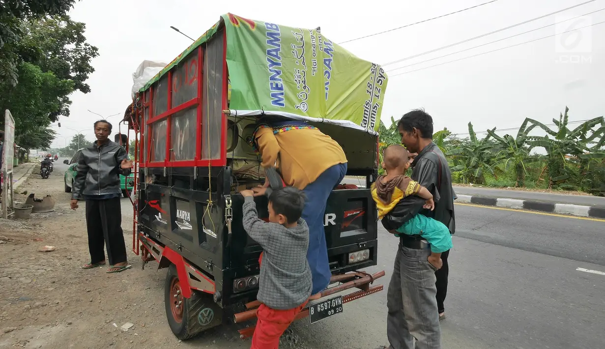 Pemudik bersama keluarganya menggunakan motor bak roda tiga bersiap kembali melakukan perjalanan mudik di Jalur Pantura kawasan Pemalang, Jawa Tengah, Senin (3/6/2019). Keluarga ini sudah sejak tiga tahun lalu menggunakan motor bak roda tiga untuk mudik. (Liputan6.com/Herman Zakharia)