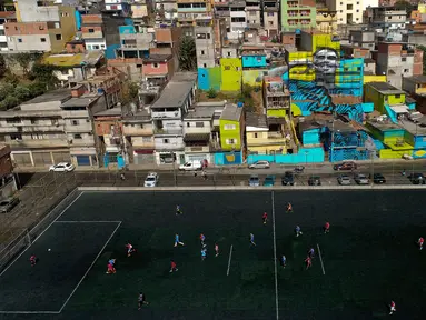 Pemandangan saat anak-anak bermain sepak bola di sebuah lapangan di Jardim Peri, Sao Paulo, Brasil, Minggu (20/5). Daerah ini merupakan tempat di mana pemain sepak bola profesional Gabriel Jesus tumbuh. (AP Photo/Andre Penner)