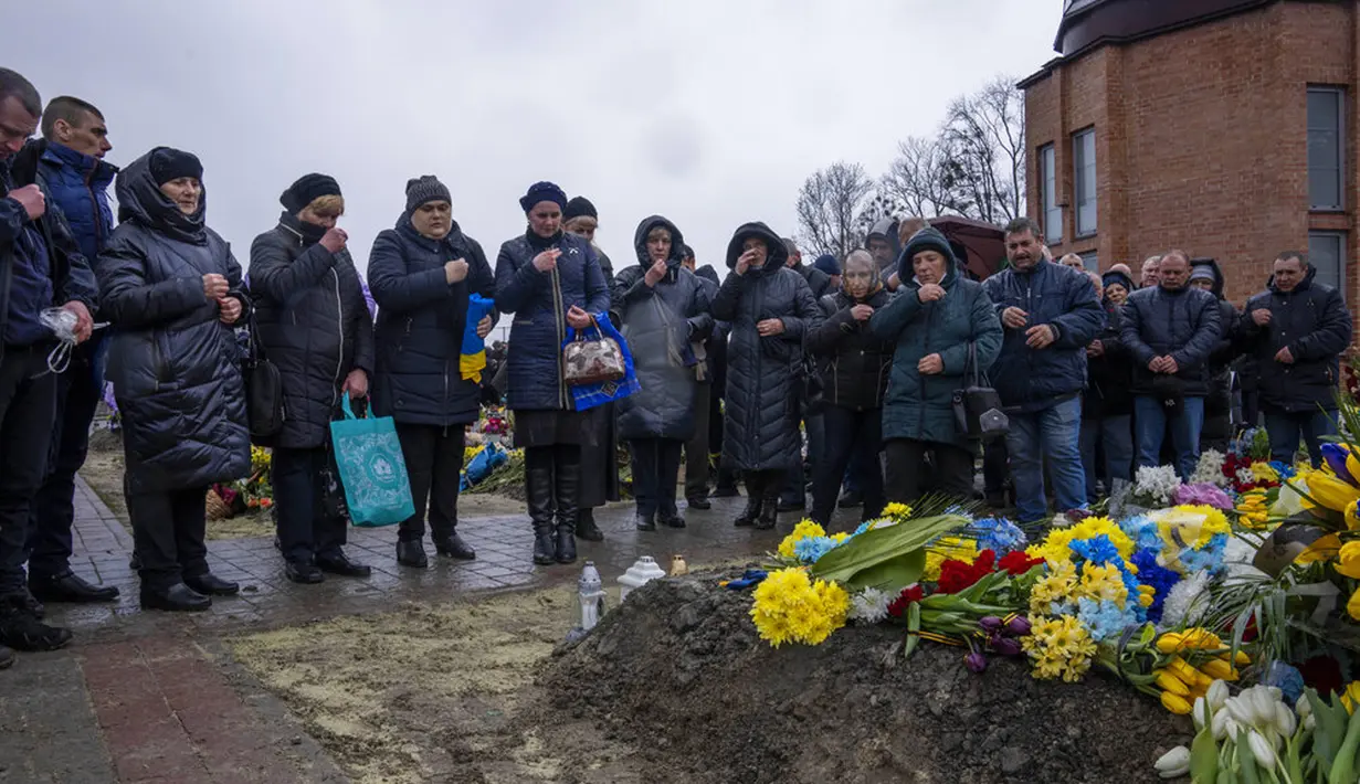 Keluarga dan teman menghadiri pemakaman seorang tentara yang tewas dalam perang dengan Rusia di pemakaman Lychakiv, Lviv, Ukraina, Selasa (5/4/2022). (AP Photo/Nariman El-Mofty)