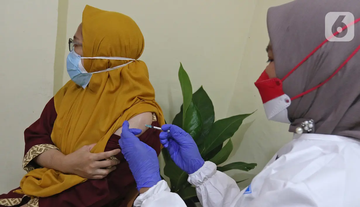 Vaksinator menyuntikkan vaksin Covid-19 dosis ketiga atau booster kepada tenaga medis di RSUD Matraman, Jakarta, Jumat (6/8/2021). Pemberian vaksin dosis ketiga kepada tenaga kesehatan di Indonesia ditargetkan rampung pada pekan kedua Agustus 2021 (Liputan6.com/Herman Zakharia)