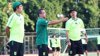 Mustaqim (kanan) berbincang dengan Aji Santoso (tengah) dalam sesi latihan Persebaya Surabaya. (Bola.com/Aditya Wany)