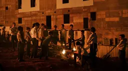 Ultra-Ortodoks Yahudi menyalakan api unggun selama hari libur Yahudi perayaan Lag Ba'Omer di Bnei Brak, Israel, Kamis (29/4/2021). Liburan Lag Ba'Omer, menandai berakhirnya wabah yang dikatakan telah membinasakan orang Yahudi selama zaman Romawi. (AP Photo/Sebastian Scheiner)