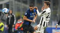Pemain Juventus Federico Chiesa (kanan) berebut bola dengan pemain Inter Milan Roberto Gagliardini pada pertandingan Serie A di Stadion San Siro, Milan, Italia, Minggu (24/10/2021). Pertandingan berakhir dengan skor 1-1. (AP Photo/Luca Bruno)