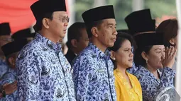 Ahok, Jokowi dan Iriana saat menghadiri Upacara HUT Korps Pegawai Republik Indonesia (Korpri) ke-43 di halaman Monumen Nasional (Monas), Jakarta, Senin (1/12/2014). (Liputan6.com/Faizal Fanani)