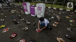 Pegiat komnas perempuan saat melakukan aksi diam 500 Langkah Awal Sahkan RUU PKS di depan gedung DPR, Jakarta, Rabu (25/11/2020). Dalam aksinya mereka menyusun sepatu sebagai simbol "semua peduli, semua terlindungi, stop sexual violence". (Liputan6.com/Johan Tallo)