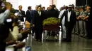 Pengusung jenazah mengawal peti mati mendiang Muhammad Ali yang hendak disalatkan di Louisville, Kentucky, AS, Kamis (9/6). Jenazah Muhammad Ali terbaring di peti mati yang dilapisi kain bertuliskan bahasa Arab berwarna hitam dan emas. (JIM WATSON/AFP)