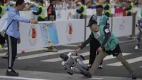 Sebuah robot humanoid kehilangan keseimbangan saat melewati garis finis dalam ajang lari half marathon yang berlangsung di Beijing, China, Sabtu (19/04/2025). (AP Photo/Ng Han Guan)