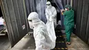 Pekerja memindahkan jenazah korban virus corona dari wadah (kontainer) berpendingin ke dalam peti mati di luar kamar mayat Rumah Sakit Thammasat, utara Bangkok, Rabu (4/8/2021). Thailand mencapai rekor tertinggi yakni lebih dari 20.000 kasus infeksi baru dalam sehari. (Lillian SUWANRUMPHA/AFP)