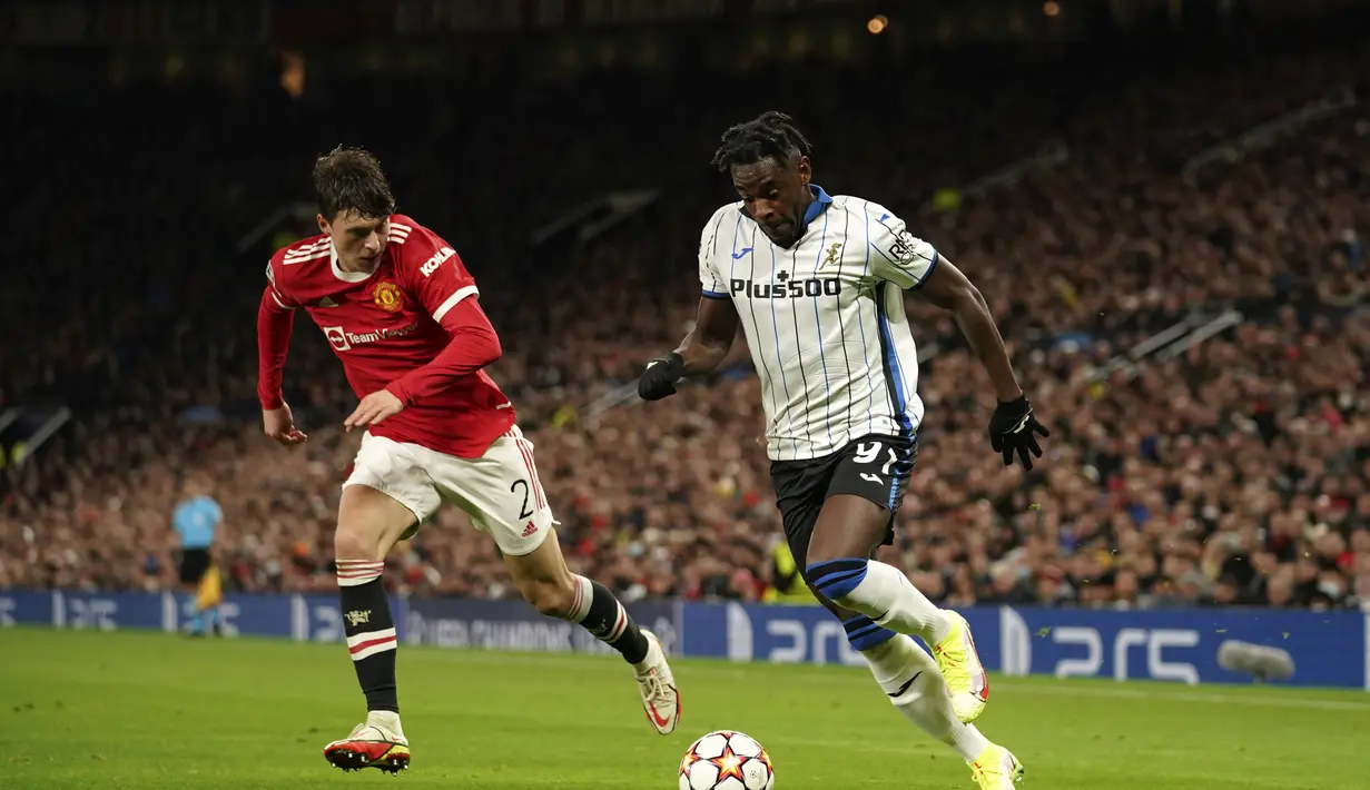 Penyerang Atalanta, Duvan Zapata berusaha melewati bek Manchester United, Victor Lindelof pada pertandingan lanjutan Grup F Liga Champions di Old Trafford, Inggris, Kamis (21/10/2021). MU menang tipis atas Atalanta 3-2. (AP Photo/Dave Thompson)