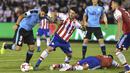 Striker Uruguay, Luis Suarez, berebut bola dengan gelandang Paraguay, Cristian Riveros, pada laga kualifikasi piala dunia 2018 di Stadion Defensores del Chaco, Rabu (6/9/2017). Uruguay menang 2-1 atas Paraguay. (AFP/Daniel Duarte)