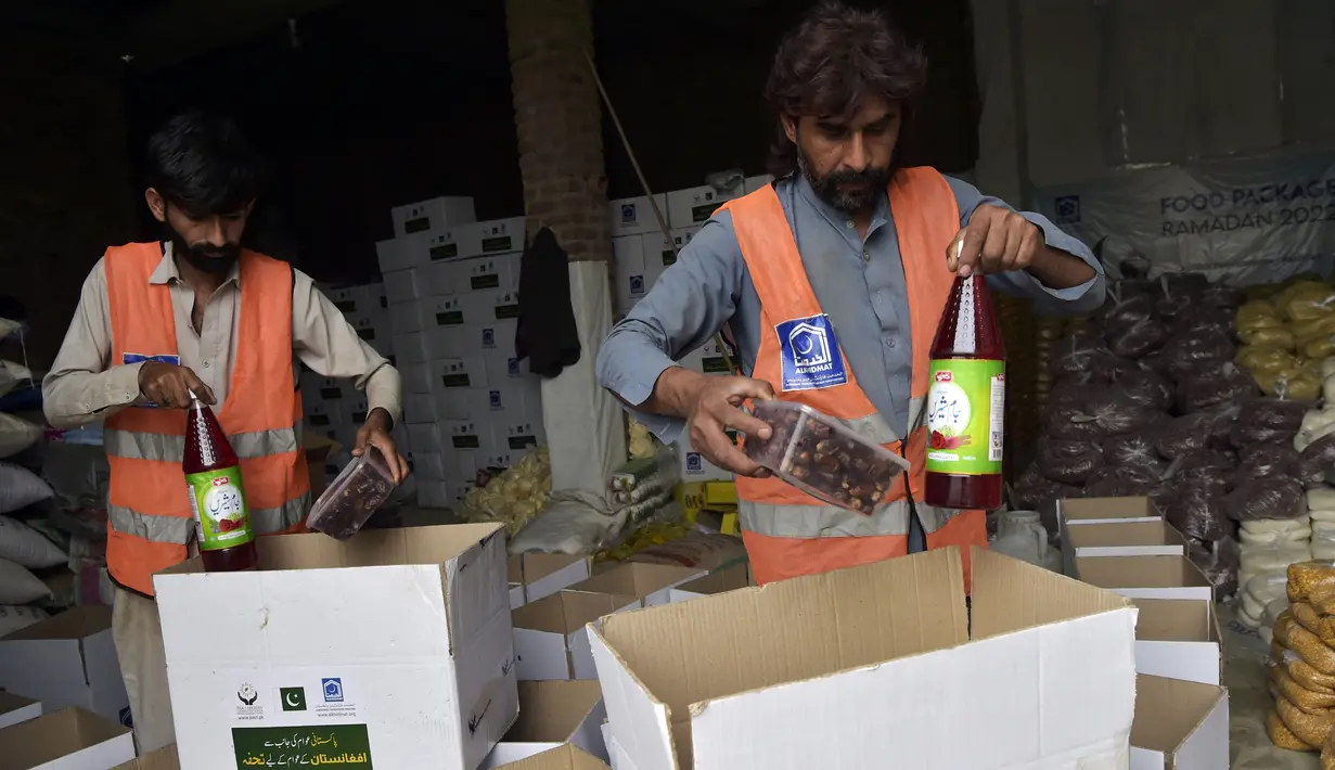Aktivis Yayasan Al khidmat Pakistan, sebuah organisasi nirlaba, mengemas makanan berbuka puasa untuk dikirim ke Afghanistan jelang awal bulan suci Ramadhan di Peshawar, Pakistan, 23 Maret 2022. (Abdul MAJEED/AFP)