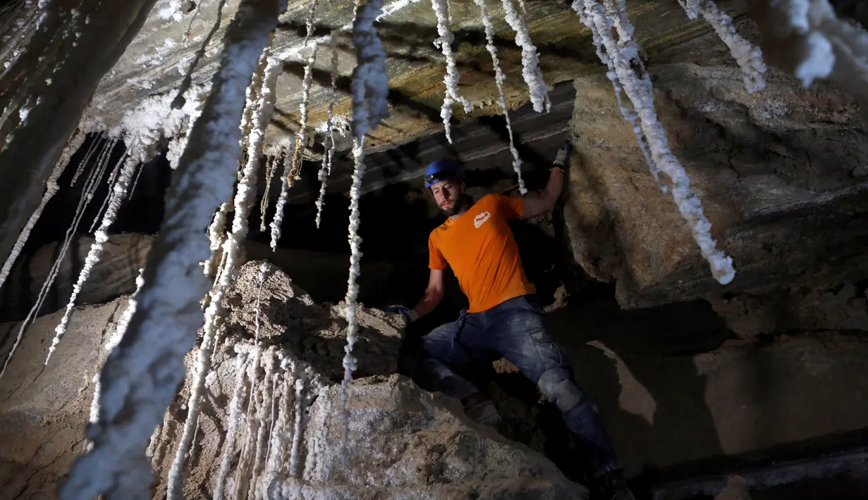 Anggota Pusat Penelitian Gua Universitas Hebrew, Efraim Cohen berdiri dekat stalaktit garam dalam Gua Malham di Gunung Sodom, Israel, Rabu (27/3). Gua garam yang besar adalah struktur geologi langka, ini karena garam sangat mudah larut di air. (REUTERS/Nir Elias)