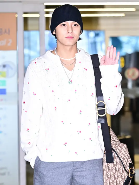 Mingyu mengenakan atasan knit lengan putih dengan motif bunga mawar dipadukan celana panjang abu-abu.  [Dok. Dior]