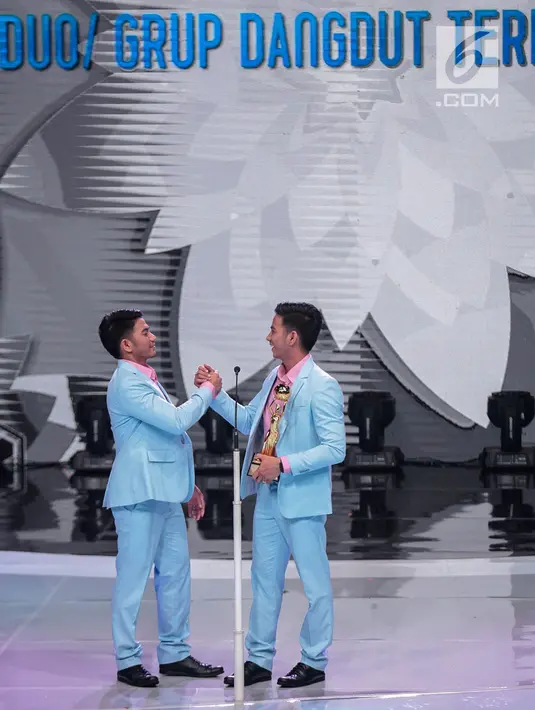 Ekspresi Rizki-Ridho DA (Dangdut Akademi) salam komando saat memperoleh penghargaan kategori duo/grup dangdut terpopuler dalam Indonesian Dangdut Awards 2018 di Studio 5 Indosiar, Jakarta, Jumat (12/10). (Liputan6.com/Faizal Fanani)