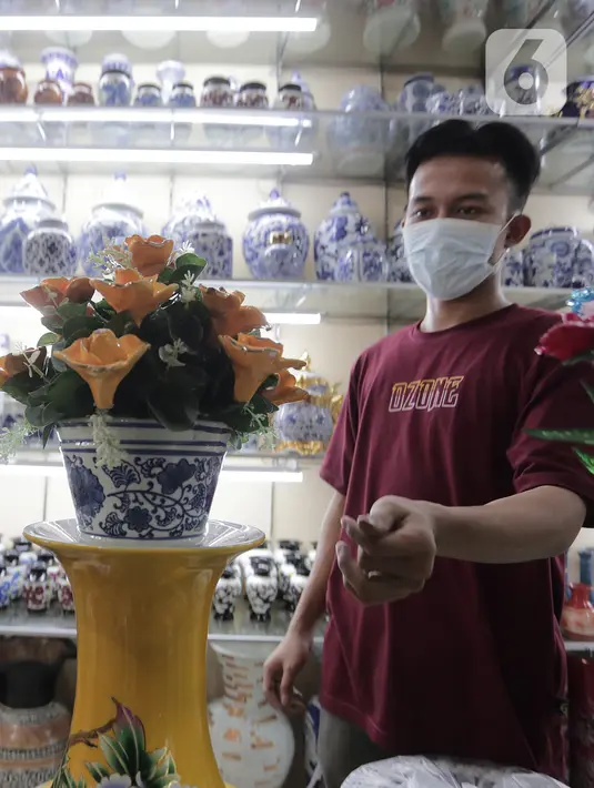 Pembeli melihat produk keramik yang dijual di kios kerajinan keramik kawasan Tanjung Priuk, Jakarta Utara, Kamis (23/9/2021). Pedagang mengaku pasokan keramik menurun hingga 70 persen seiring dangan pembatasan produksi pabrik akibat perpanjangan PPKM. (Liputan6.com/Herman Zakharia)