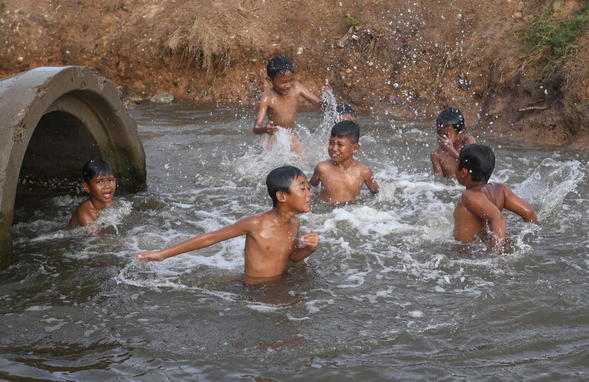 FOTO: Keceriaan Anak-Anak Bermain Pada Saluran Air di Tanjung Pasir