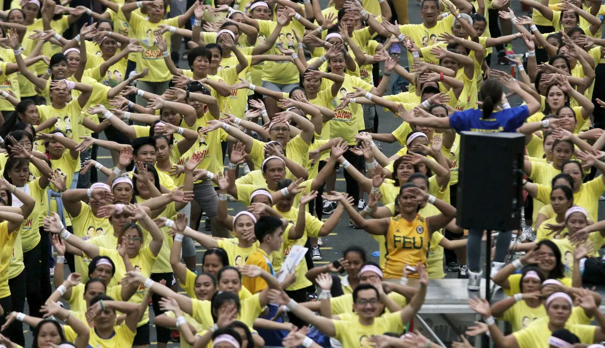 Seorang instruktur memimpin gerakan saat kelas zumba terbesar yang diadakan di sepanjang jalan utama Manila, Filipina, Minggu (19/7/2015). Warga Filipina memecahkan rekor Guinness World Records dengan peserta mencapai 12, 975. (REUTERS/Lorgina Minguito)