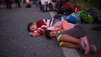 Anak-anak Rombongan imigran Amerika Tengah tujuan Amerika Serikat menunggu tumpangan di sisi jalan saat melangsungkan perjalanan dekat Tapanatepec, Meksiko, Senin (29/10). (AP Photo/Rodrigo Abd)