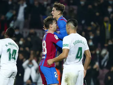 Gelandang Barcelona Nico Gonzalez berselebrasi dengan rekan setimnya setelah mencetak gol ke gawang Elche pada jornada ke-18 Liga Spanyol di Stadion Camp Nou, Minggu (19/12/2021) dini hari WIB. Barcelona menang 3-2 atas Elche. (AP Photo/Joan Monfort)