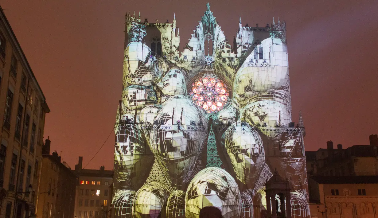 Karya instalasi lampu seniman Yann Nguema, menghiasi bangunan Gereja Katedral Saint-Jean saat persiapan Festival of Lights (Fete des Lumieres) di pusat Kota Lyon, Prancis (7/12). (Reuters/Emmanuel Foudrot)