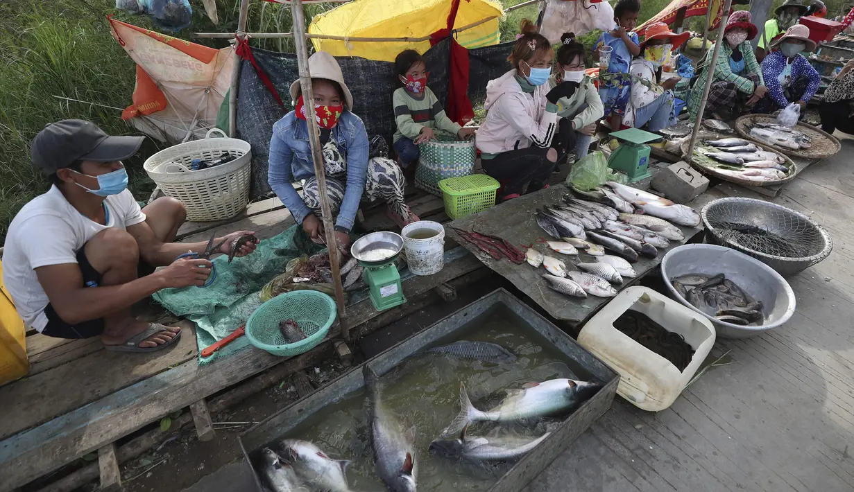 Etnis Vietnam menjual ikan di sepanjang trotoar dekat desa Prek Pnov di Phnom Penh, Kamboja, Kamis (5/8/2021). Prek Pnov terkenal dengan peternakan ikannya dan memasok banyak pasar di Phnom Penh. (AP Photo/Heng Sinith)