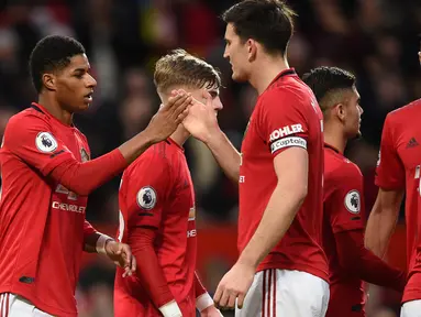 Striker Manchester United, Marcus Rashford (kiri) berselebrasi dengan rekan-rekannya usai mencetak gol ke gawang Norwich City pada pertandingan lanjutan Liga Inggris di Old Trafford (11/1/2020). Rashford mencetak dua gol dan mangantar MU menang telak 4-0 atas Norwich. (AFP/Oli Scarff)