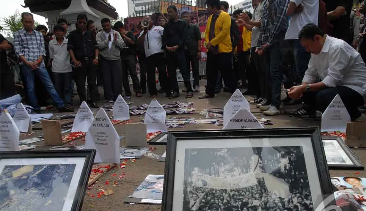 Para pedemo berdoa bersama di dekat nisan kayu. Mereka juga membawa foto dari peristiwa 98 yang telah menewaskan mahasiswa dari Trisakti, Jakarta, Selasa (24/06/2014) (Liputan6.com/Faisal R Syam)