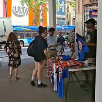 Para pedagang kaki lima menjajakan kaus bergambar New York Knicks yang berlaga di final NBA 2026 di Sixth Avenue, Jumat (12/06/2026) siang waktu setempat. (Bola.com/Hery Kurniawan)